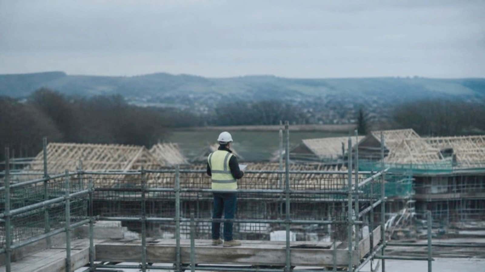 A site manager on the scaffold at the end of the day, looking out over the job